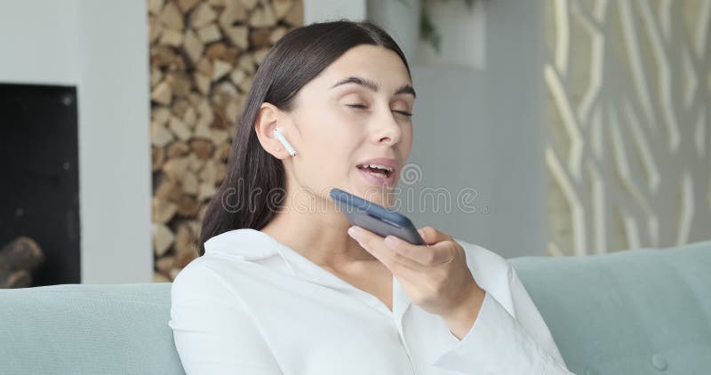 Jeune femme souriante enregistrant un message audio à un ami banque de vidéos