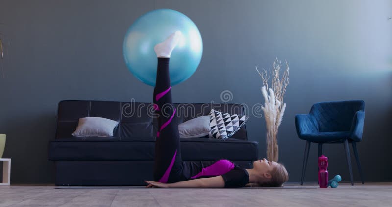 Jeune femme sportive faisant l'exercice avec le fitball