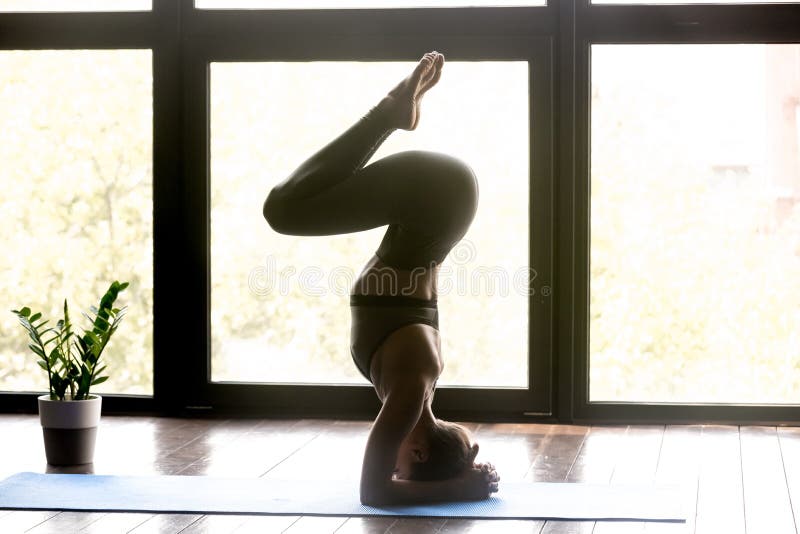 Jeune femme sportive faisant l'exercice de headstand de yoga photo stock Jeune femme sportive faisant l'exercice de headstand de yoga photo stock