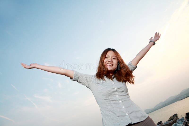 Jeune femme sur la plage au coucher du soleil photo libre de droits Jeune femme sur la plage au coucher du soleil photo libre de droits