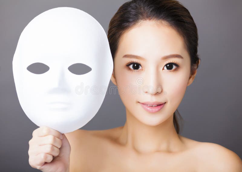 Jeune femme tenant le masque blanc pour la beauté médicale image stock Jeune femme tenant le masque blanc pour la beauté médicale image stock