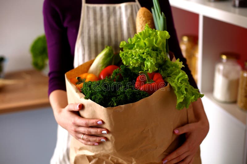 Jeune femme tenant le sac d'épicerie avec photos stock Jeune femme tenant le sac d'épicerie avec photos stock