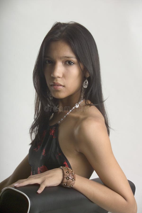 Jeune femme triste s'asseyant dans une présidence image libre de droits Jeune femme triste s'asseyant dans une présidence image libre de droits