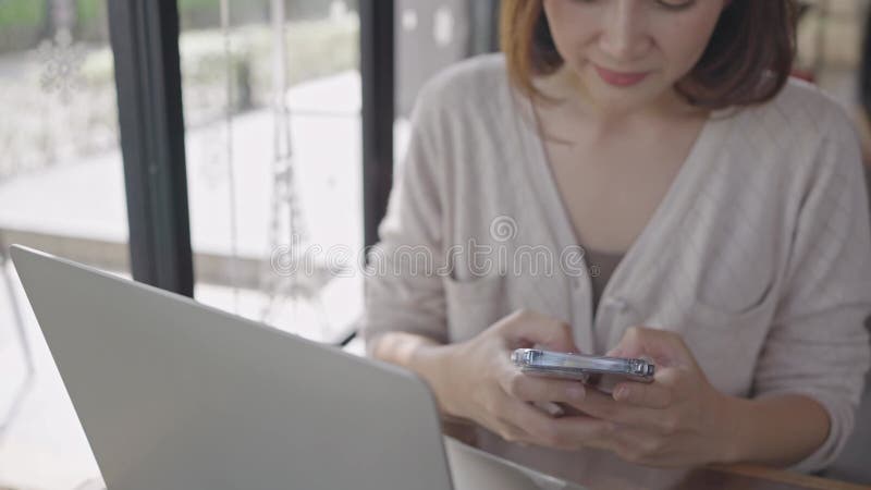 Jeune femme utilisant smartphone vérifier les médias sociaux sur internet dans le café souriant heureux banque de vidéos