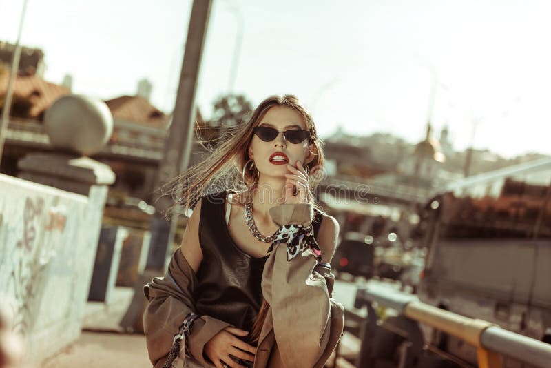 Jeune femme à la mode utilisant les vêtements et les lunettes de soleil élégants photos stock Jeune femme à la mode utilisant les vêtements et les lunettes de soleil élégants photos stock