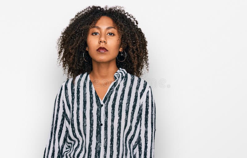 Jeune fille afro-américaine portant des vêtements décontractés avec une expression sérieuse sur le visage photo libre de droits