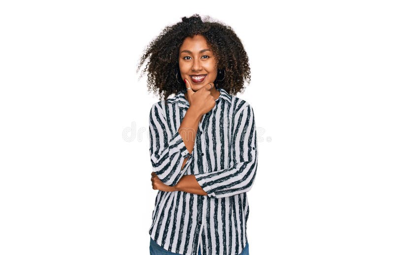Jeune fille afro-américaine portant des vêtements décontractés regardant confiant la caméra souriant avec les bras croisés et la m photographie stock