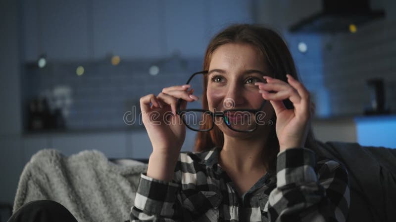 Jeune fille attirante prenant et portant des lunettes dans une salle du soir clips vidéos