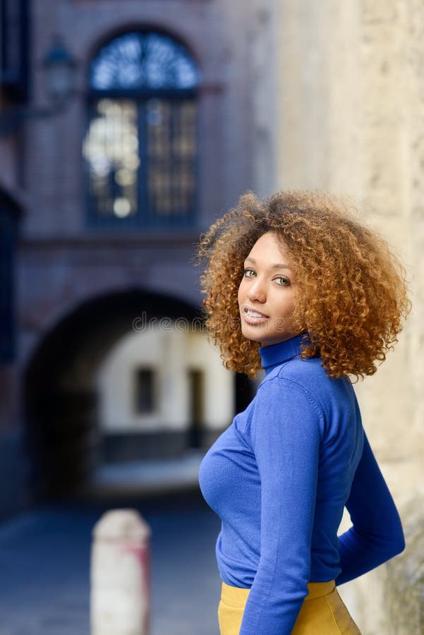 Jeune fille avec la coiffure Afro à l'arrière-plan urbain photos stock Jeune fille avec la coiffure Afro à l'arrière-plan urbain photos stock
