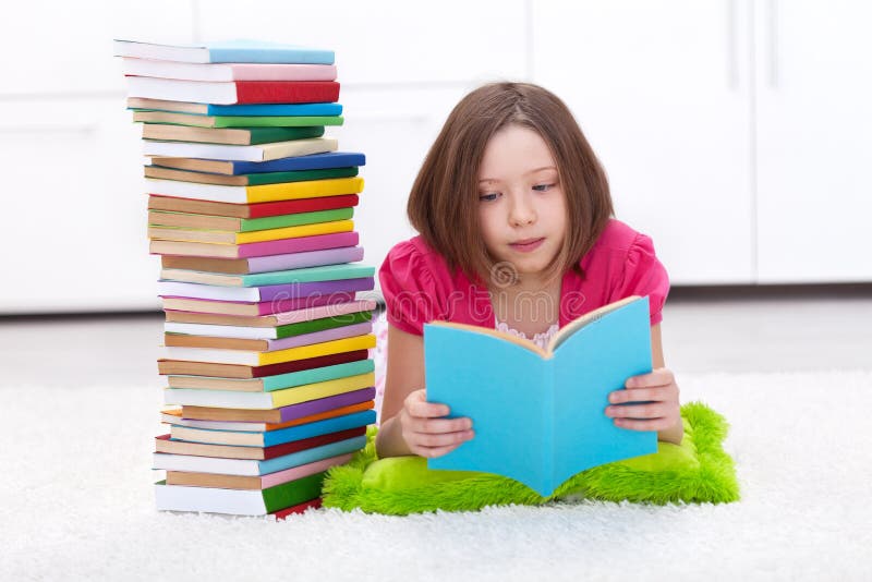 Young girl with lots of books reading on the floor. Young girl with lots of books reading on the floor