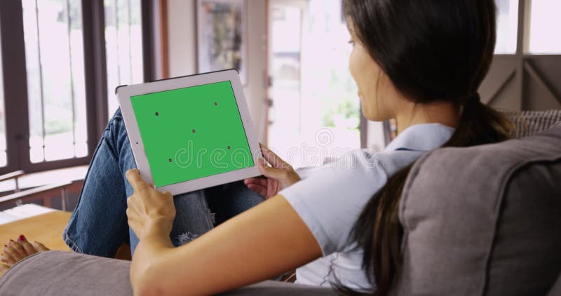 Jeune fille blanche bavarde sur sa tablette avec écran vert