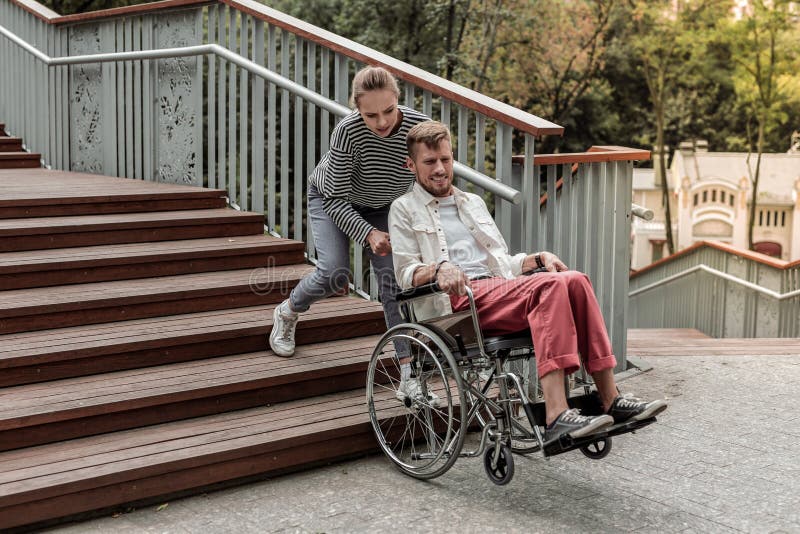 Jeune fille blonde aidant son associé handicapé photo stock