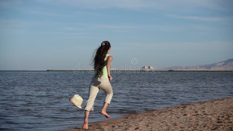 Jeune fille courant loin à la plage dans la station de vacances de l'Egypte, motio lent banque de vidéos