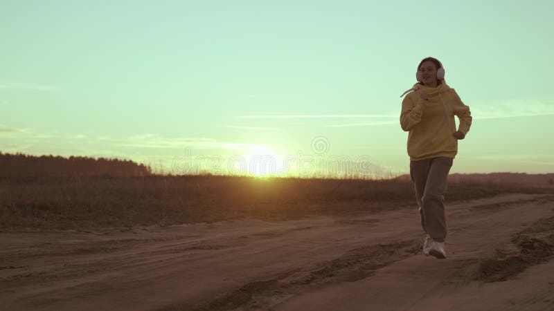 Jeune fille court sur fond d'amour du coucher du soleil pour jouer au sport commencer la journée d'entraînement cardio le matin à photo libre de droits