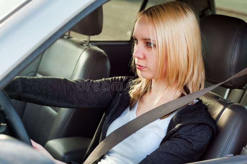 Jeune fille d'étudiant conduisant une voiture image libre de droits Jeune fille d'étudiant conduisant une voiture image libre de droits