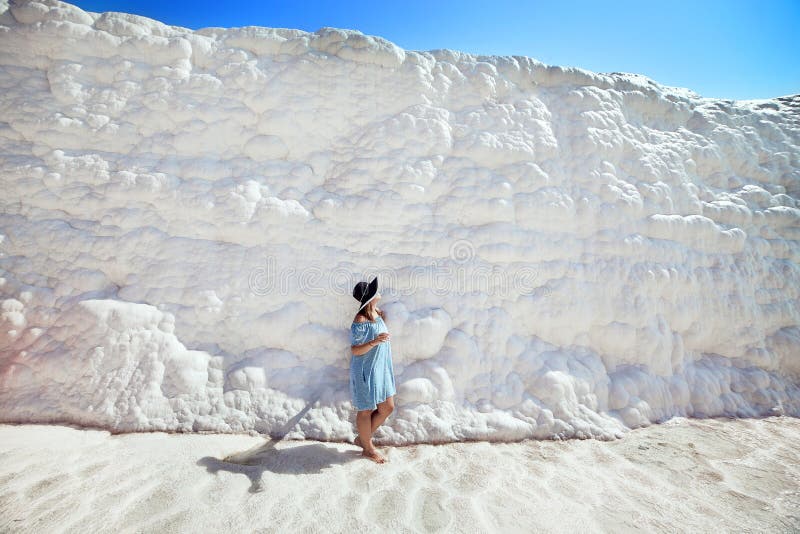 Jeune fille dans le chapeau regardant sur des piscines et des terrasses de travertin dans Pamukkale Ch?teau de coton en Turquie d image stock Jeune fille dans le chapeau regardant sur des piscines et des terrasses de travertin dans Pamukkale Ch?teau de coton en Turquie d image stock