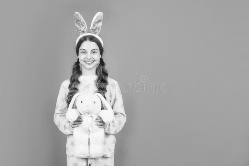 Jeune fille de pâques heureux dans des oreilles de lapin lapin lapin lapin et pyjama jouer avec jouet copie espace Pâques photos libres de droits