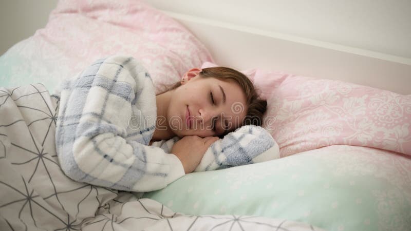 Jeune Fille Dormant Doucement Dans Un Lit En Pyjamas banque de vidéos
