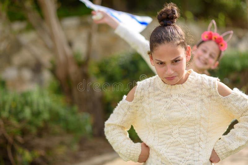 Jeune fille drôle d'adolescent se tenant extérieure avec des bras sur les hanches image libre de droits Jeune fille drôle d'adolescent se tenant extérieure avec des bras sur les hanches image libre de droits