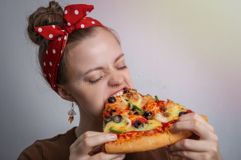 Jeune fille du caucase de femme mordant dévorant une grande pizza. Concept de faim