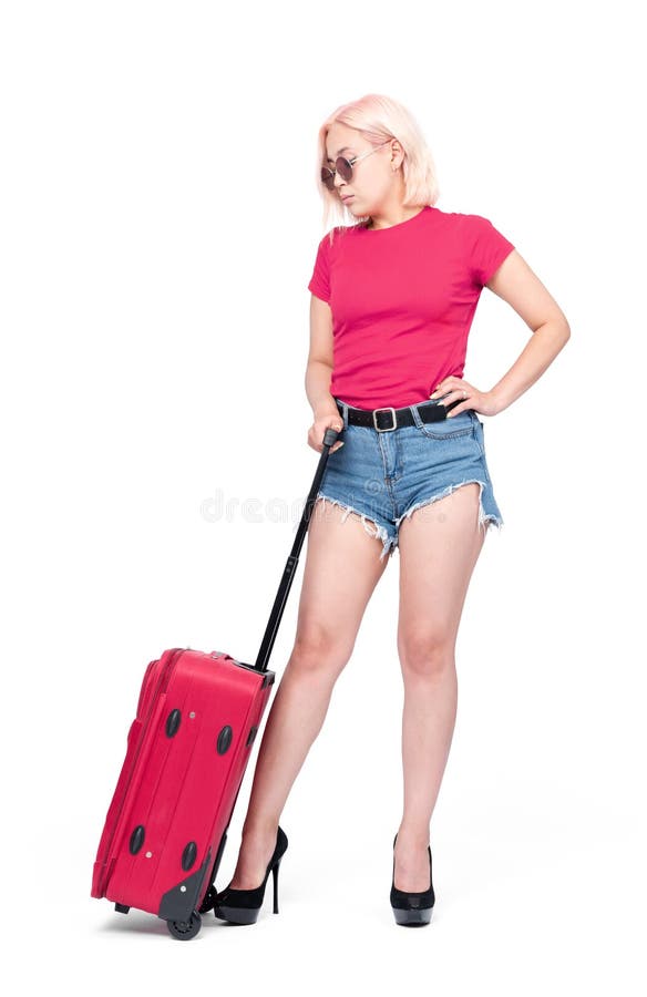 Jeune fille en bref et les supports roses de T-shirt avec une valise, d'isolement sur le fond blanc images libres de droits Jeune fille en bref et les supports roses de T-shirt avec une valise, d'isolement sur le fond blanc images libres de droits