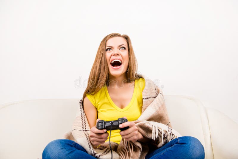 Jeune fille enthousiaste dans le rire écossais jouant le jeu vidéo image stock
