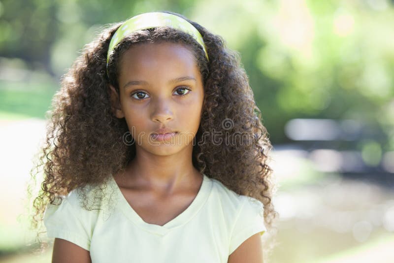 Jeune fille fronçant les sourcils à l'appareil-photo en parc photo stock