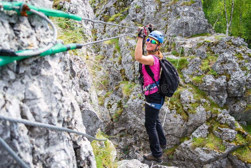 Jeune fille heureuse croisant a par l'intermédiaire du pont en fil de ferrata en Baia de Fier, Roumanie Pont indien sur un klette photo libre de droits Jeune fille heureuse croisant a par l'intermédiaire du pont en fil de ferrata en Baia de Fier, Roumanie Pont indien sur un klette photo libre de droits