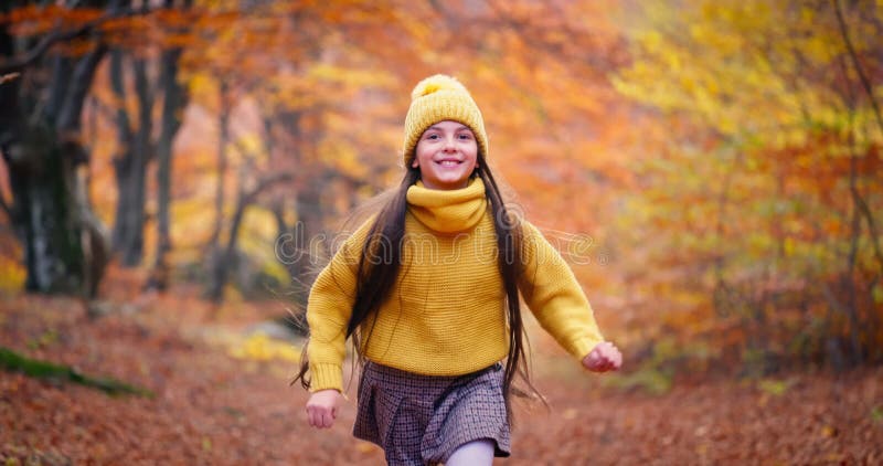 Jeune fille heureuse en courant à travers une forêt d'automne colorée. les images évoquent un sentiment de détente d'aventure et d clips vidéos