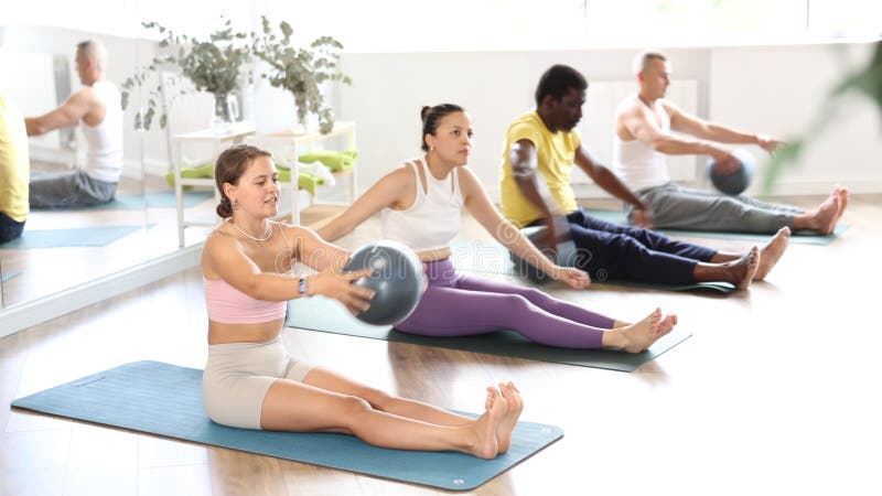 Jeune fille joyeuse instructeur de fitness guide groupe pilates sessions dans un studio chaud éclairé se produisant partout dans l clips vidéos