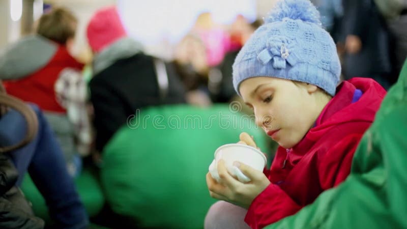 Jeune fille mange de la crème glacée et s'assoit sur le sac vert banque de vidéos
