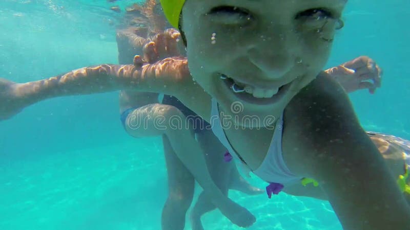 Jeune fille nage sous l'eau de la piscine à l'été ensoleillé clips vidéos