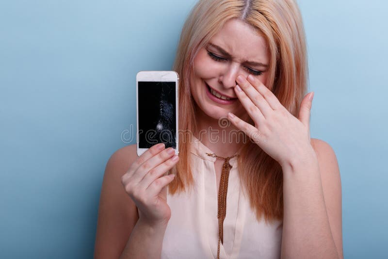 Jeune fille, pleurant jugeant un téléphone portable cassé disponible Plan rapproché Un déjeuner sec dans une cuillère image stock Jeune fille, pleurant jugeant un téléphone portable cassé disponible Plan rapproché Un déjeuner sec dans une cuillère image stock