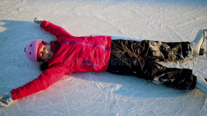 Jeune fille s'allonge sur la glace et fait mouvement dans clips vidéos