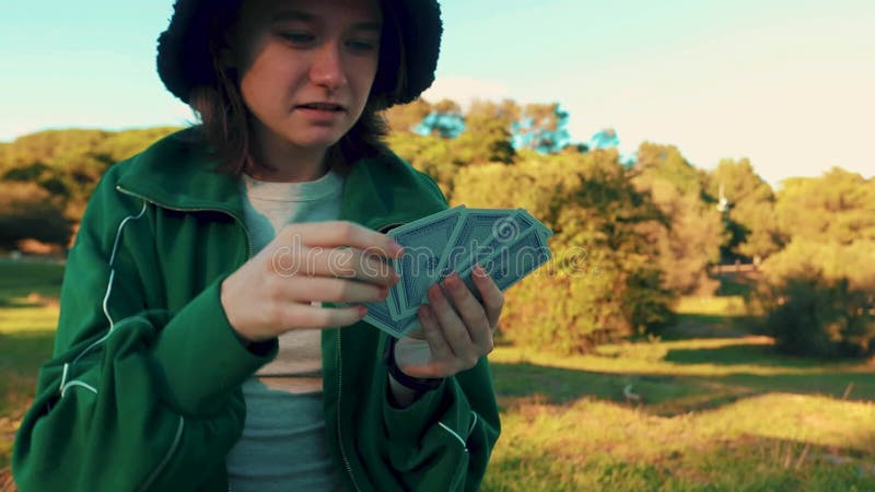 Jeune fille souriante jouant jeu de carte avec la famille. loisirs créatifs en plein air et éducation des enfants. activité famili banque de vidéos