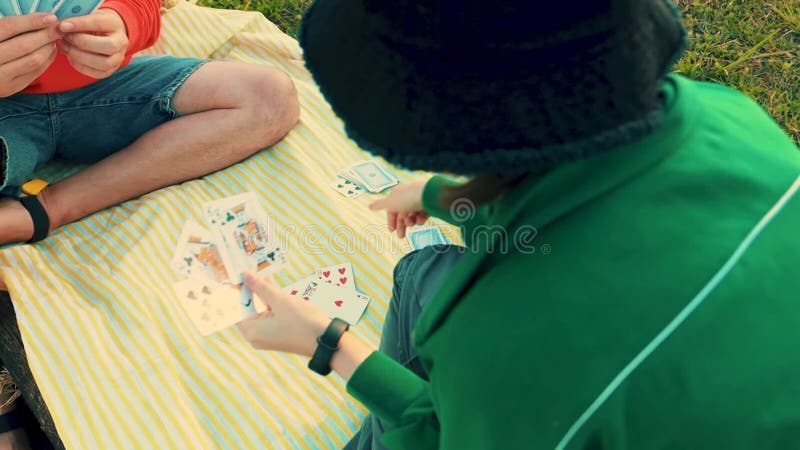 Jeune fille souriante jouant jeu de carte avec la famille. loisirs créatifs en plein air et éducation des enfants. activité famili clips vidéos