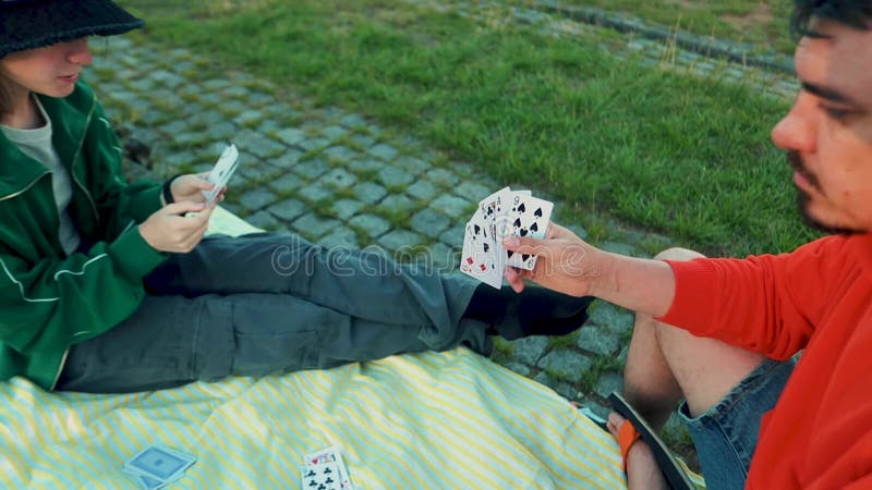 Jeune fille souriante jouant jeu de carte avec la famille. loisirs créatifs en plein air et éducation des enfants. activité famili banque de vidéos