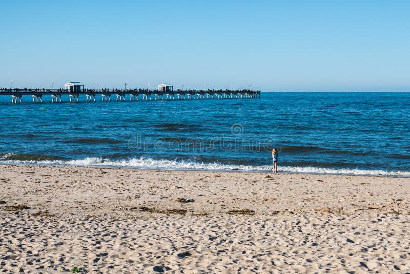 Jeune fille sur la plage de vue d'océan en Norfolk, la Virginie image stock Jeune fille sur la plage de vue d'océan en Norfolk, la Virginie image stock