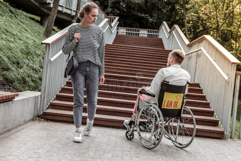 Jeune fille sérieuse regardant l'homme invalide images libres de droits