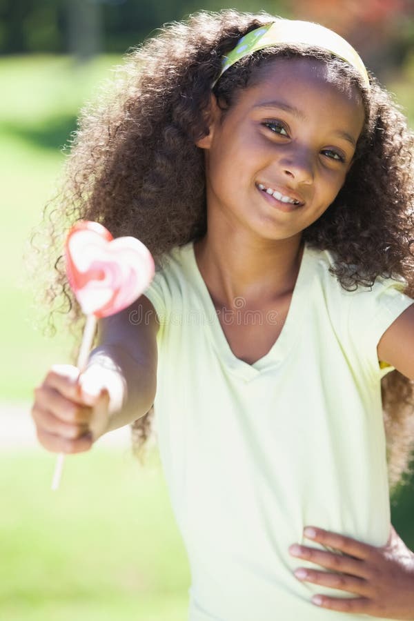 Jeune fille tenant une lucette de coeur en parc image libre de droits