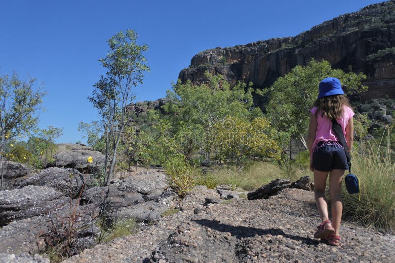 Jeune fille trimardant au site d'art de roche de Burrungkuy Nourlangie dans le territoire du nord de parc national de Kakadu de l photo libre de droits Jeune fille trimardant au site d'art de roche de Burrungkuy Nourlangie dans le territoire du nord de parc national de Kakadu de l photo libre de droits