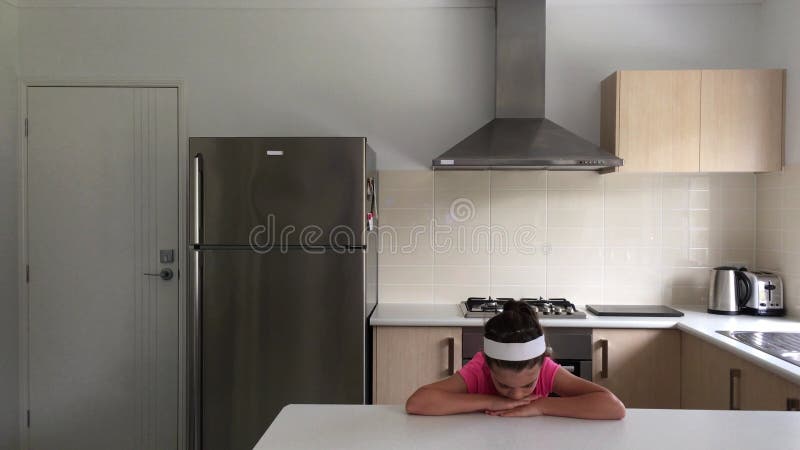 Jeune fille triste à pleurer dans la cuisine à la maison clips vidéos