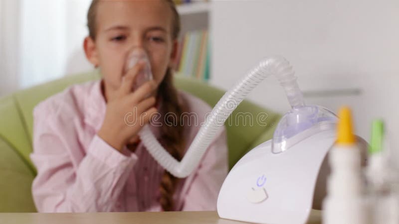 Jeune fille à l'aide de l'inhalateur de nébuliseur avec le masque banque de vidéos