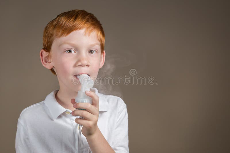Jeune garçon avec l'asthme suivant un traitement de respiration photos stock Jeune garçon avec l'asthme suivant un traitement de respiration photos stock