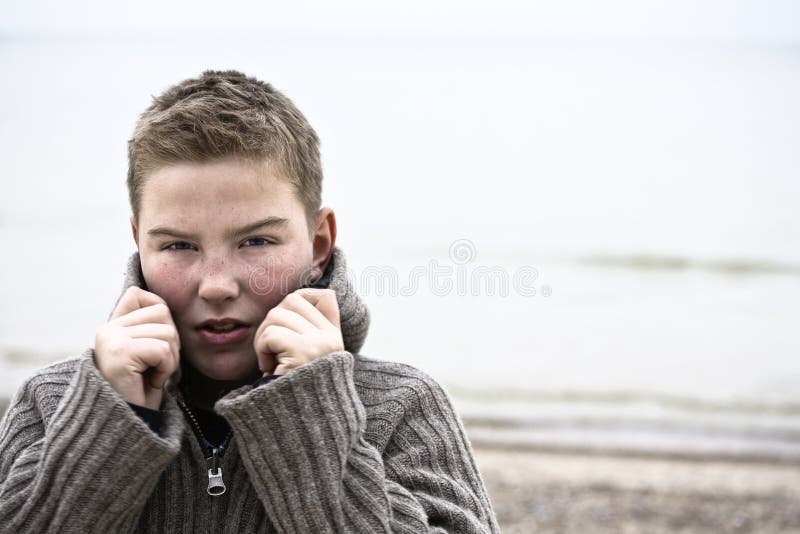 Jeune garçon beau avec le pull à l'hiver de plage images libres de droits Jeune garçon beau avec le pull à l'hiver de plage images libres de droits