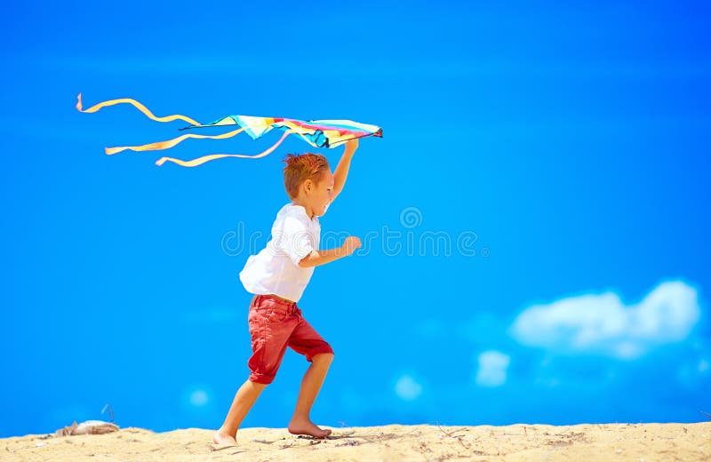 Jeune garçon heureux courant avec le cerf-volant sur le fond de ciel images libres de droits Jeune garçon heureux courant avec le cerf-volant sur le fond de ciel images libres de droits
