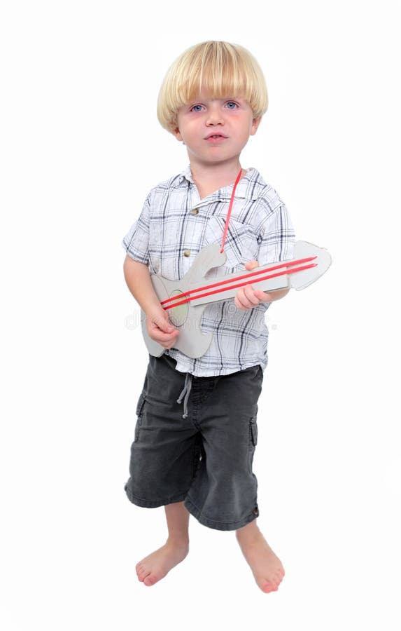 Jeune garçon jouant la guitare de carton avec le fond blanc photo stock Jeune garçon jouant la guitare de carton avec le fond blanc photo stock