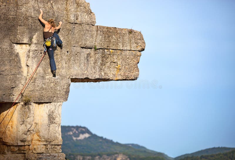 Jeune grimpeur de roche féminin sur une falaise image libre de droits Jeune grimpeur de roche féminin sur une falaise image libre de droits