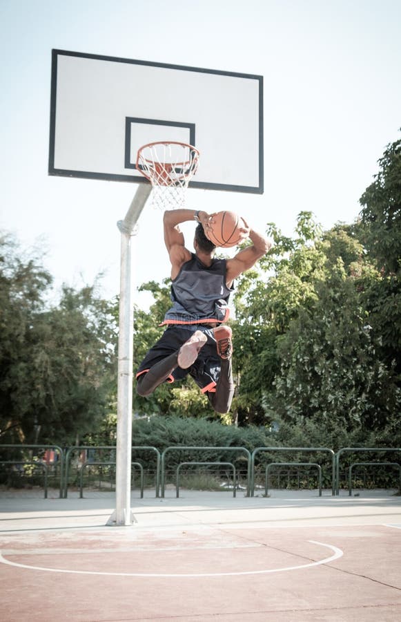 Jeune homme afro-américain jouant le basket-ball de rue en parc images libres de droits Jeune homme afro-américain jouant le basket-ball de rue en parc images libres de droits