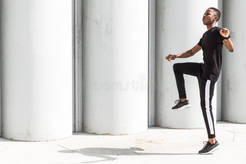 Jeune homme afro-américain sportif courant sur la promenade Coureur masculin noir sprintant dehors Style de vie sain image stock Jeune homme afro-américain sportif courant sur la promenade Coureur masculin noir sprintant dehors Style de vie sain image stock
